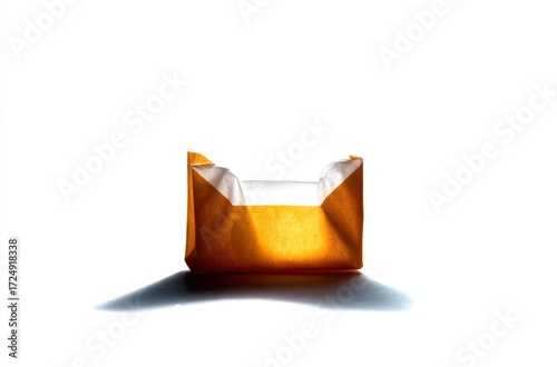 A lone, crumpled brown paper bag sits open against a stark white backdrop, casting a long shadow under a bright, harsh light