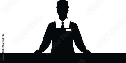 Welcoming hotel staff member standing at the reception desk ready to assist guests with check in at the modern luxury resort