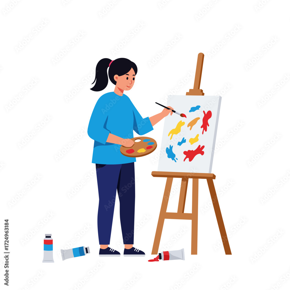 Fototapeta premium A woman with a ponytail paints colorful shapes on a canvas propped on an easel tubes of paint litter the floor