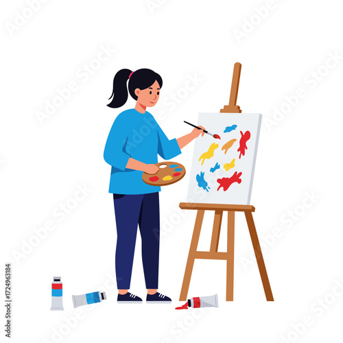 A woman with a ponytail paints colorful shapes on a canvas propped on an easel tubes of paint litter the floor