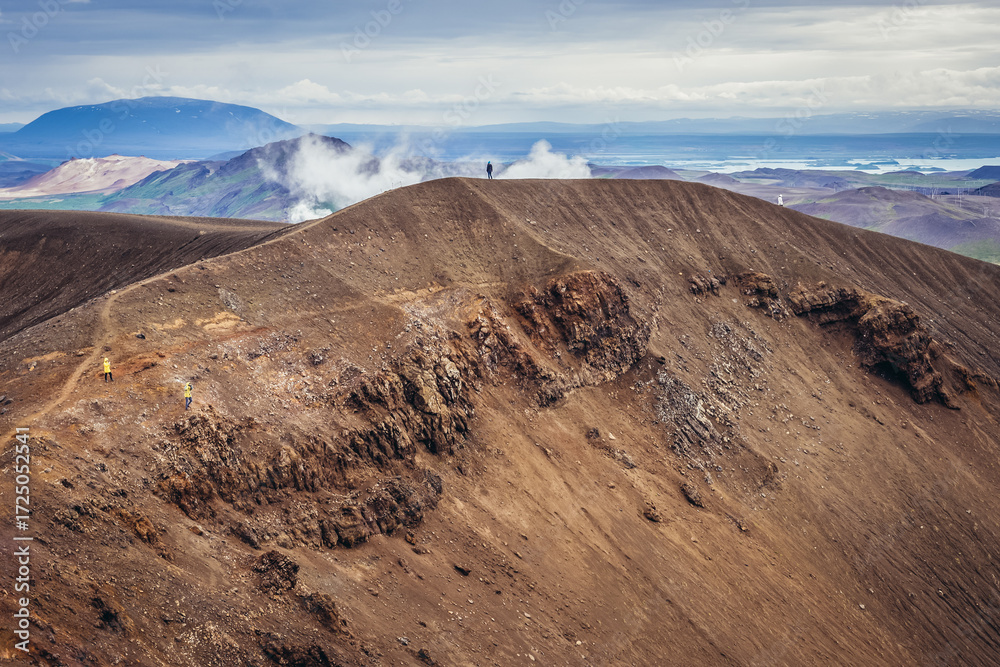 Fototapeta premium Tourists on a paths around famous crater water called Viti of Krafla volcanic caldera in Myvatn area, Iceland