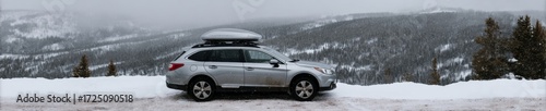 Silver SUV poised boldly on snowy mountain ridge, winter wanderlust, Alpine Fest, rugged adventure calling amid nature's frosty embrace