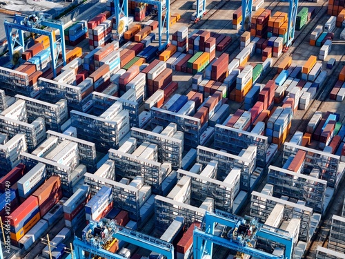 Vado Gateway, Italy - 21 September 2025: Aerial view of a vibrant tapestry of stacked shipping containers, a symphony of colors under the clear sky.