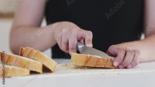 A young woman prepares fresh sandwiches with butter, sausage, and cheese on crispy bread. Close-up shots showcase the appetizing food preparation process in a modern kitchen