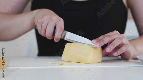 A young woman prepares fresh sandwiches with butter, sausage, and cheese on crispy bread. Close-up shots showcase the appetizing food preparation process in a modern kitchen