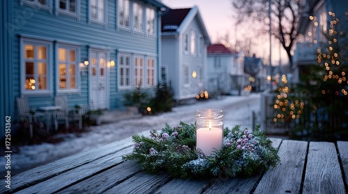Christmas Wreath Decoration on Wooden Table with Snow Covered Blue Houses and Warm Light Ambience during Holiday Season