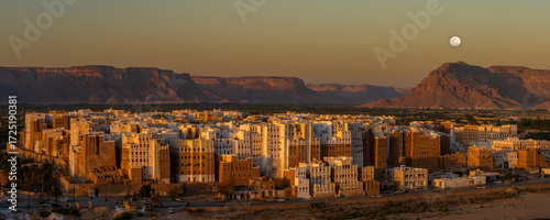Night falls with full moon over Old Walled City of Shibam, known for its mudbrick-made high-rise buildings, a world heritage site in Yemen