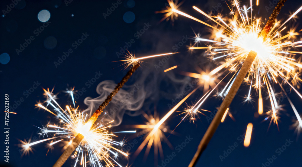 Fototapeta premium Trio of Bright Sparklers Burning Against a Dark Night Sky