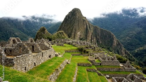 Majestic machu picchu ancient inca citadel nestled in the andes mountains, peru, with stone structures, green terraces, and misty peaks under a cloudy sky