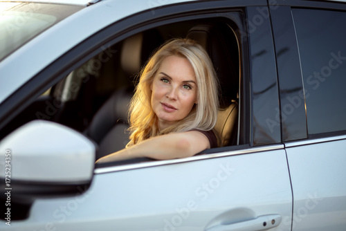 Portrait of woman sitting behind the wheel of car looking out the window.