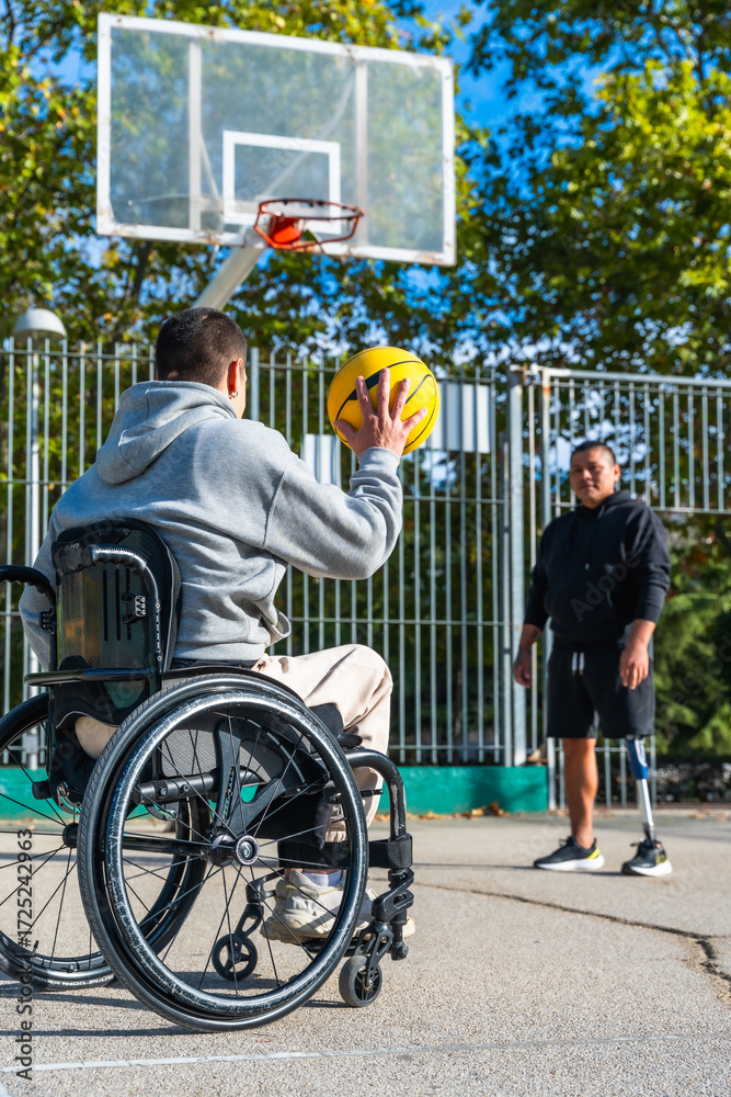 Obraz premium Man in wheelchair playing basketball with friend
