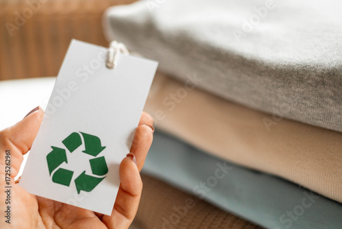 Recycled clothing tag in hand promoting eco-friendly and sustainable textile fashion