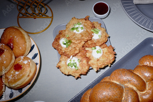 Fotografia Overhead view showing plate of potato latkes topped with sour cream and green on