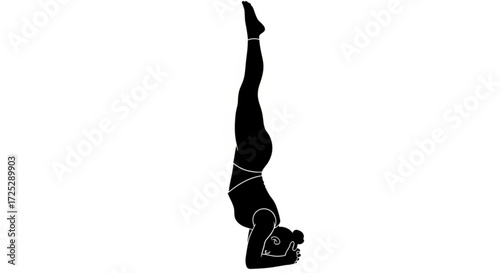 Silhouette of a woman performing a headstand, a yoga pose, the woman is wearing a chain around her waist and ankles