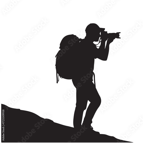 Silhouette of an outdoor photographer with a backpack and camera on a hill