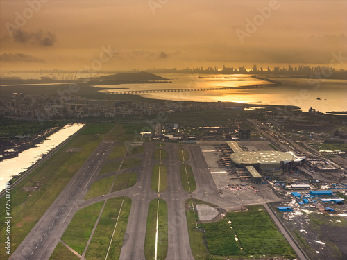 Aerial view of the ongoing construction work of Navi Mumbai International Airport(NMIA), runway, and the terminal building bathed in the warm glow of the sunset, Navi Mumbai, Maharashtra, India.