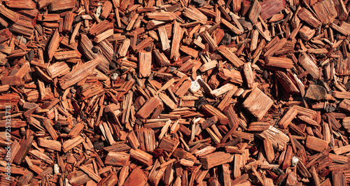 Close-up texture of brown wood chips mulch, ideal as natural background for gardening, landscaping, and organic material concepts.