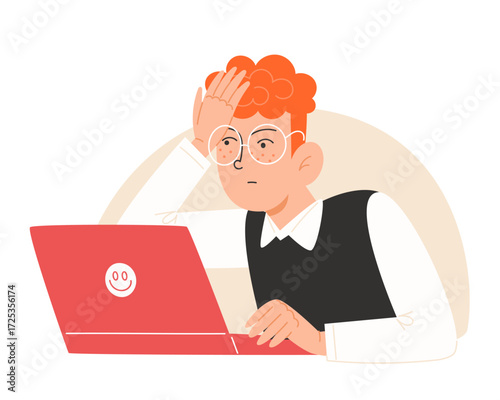 A redhaired person with glasses looks stressed at a laptop
