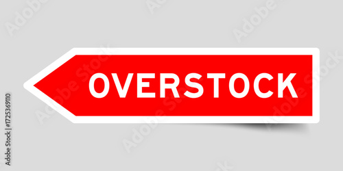 Red color arrow shape sticker label with word overstock on gray background