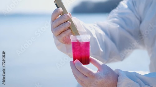 Person in protective hazmat suit and medical mask conducting water testing near lake. Environmental pollution research, contamination control, biohazard investigation, and safety inspection outdoors.
