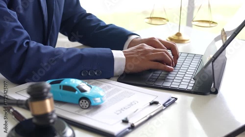 A judge holding a gavel hitting a toy car in a contract document represents automotive law, insurance disputes, car ownership, and legal decisions.