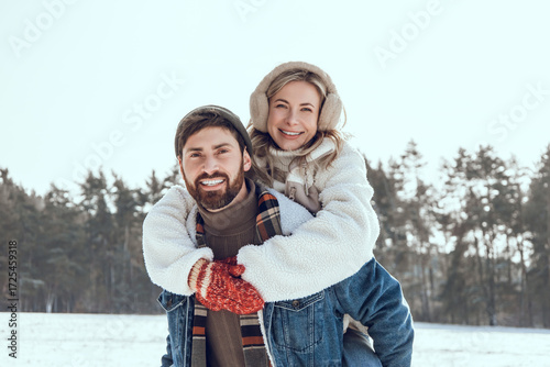 Happy couple spending time together and having fun in a winter forest