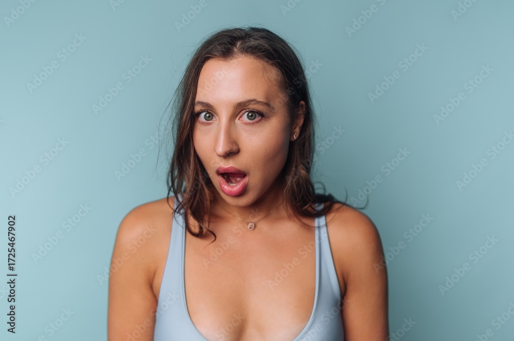 Naklejka premium Woman with surprised expression against blue background