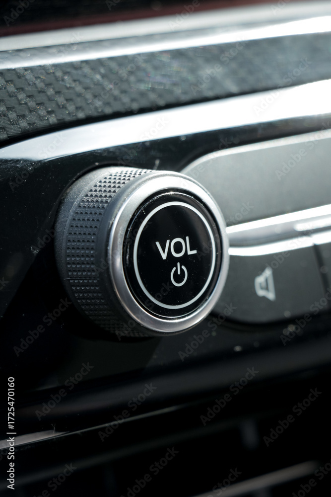 Obraz premium Sound volume tune button in car with black interior. Vertical portrait photo. 