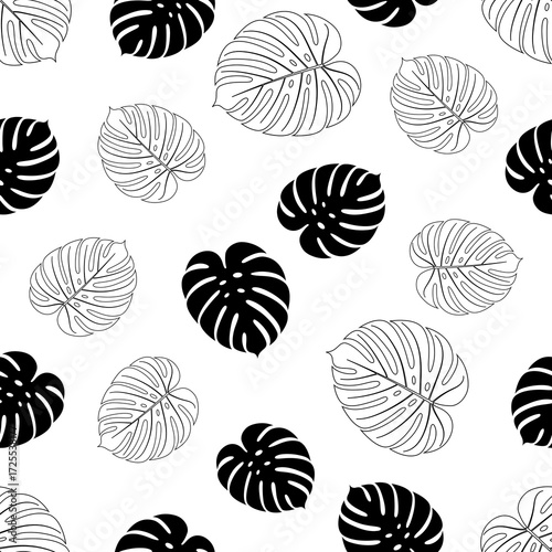 Seamless pattern of black and white monstera leaves scattered on a white background, tropical foliage design for textiles or wallpaper.