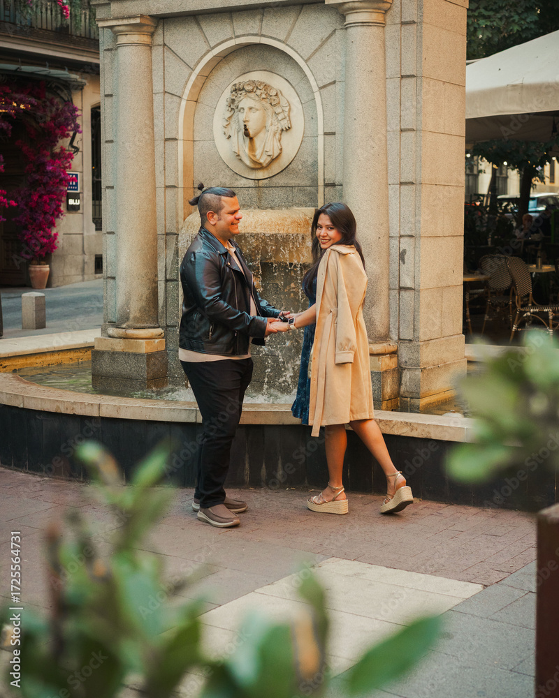 Obraz premium Couple Holding Hands in Front of Ornamental Fountain in Madrid