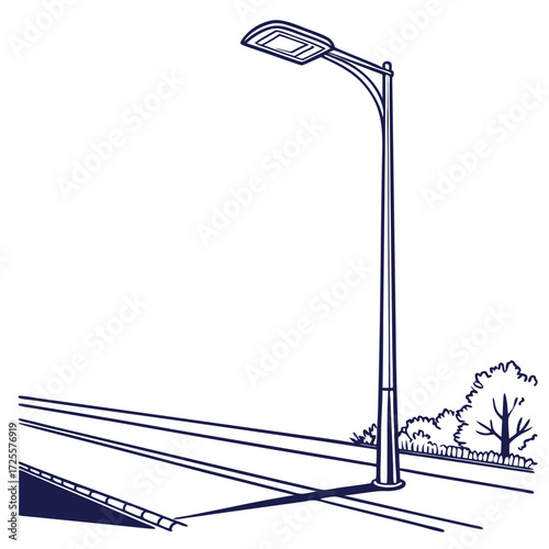 A single modern street lamp stands tall beside a road with trees and a fence in the background