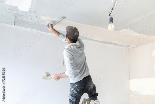 Stuckateur beim Spachteln und Glätten der Decke im Innenbereich