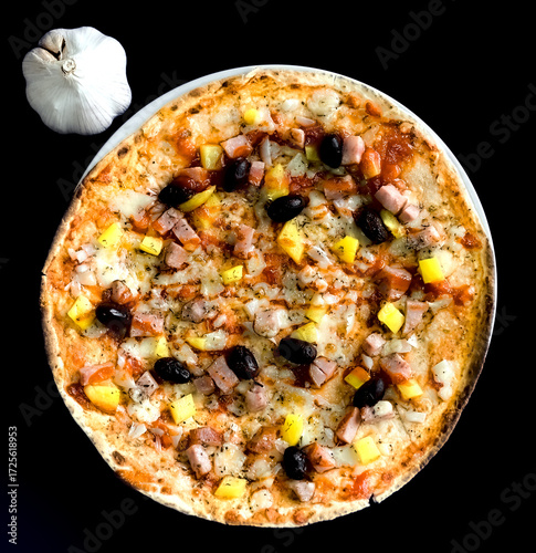 Top Up View of Tortilla Wrap Pizza With Pepper, Ham Sausage, Cheese, Olives, Tomato and Garlic on Black Background