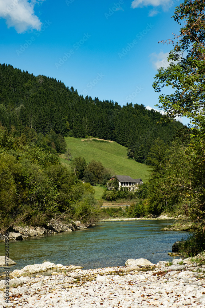 Obraz premium Idyllic Alpine Countryside with Forested Hills and Charming Austrian Settlement