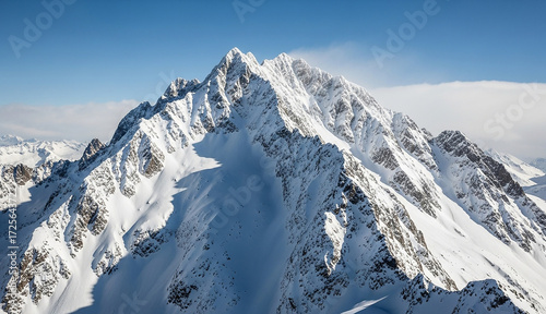 Majestic snowcapped mountain peak under a clear blue sky
