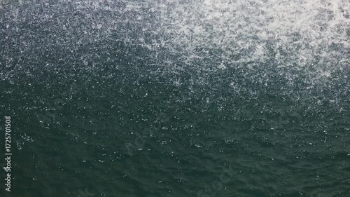 Beautiful waterfall drops splashing on water surface in slow motion calm nature background, perfect abstract video for relaxation, spa, travel, advertising and documentary projects. 120 fps video.