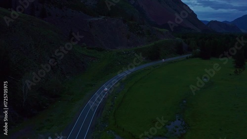 Aerial view of a car driving along a mountain road