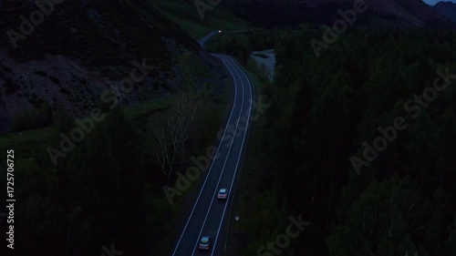 Aerial view of a car driving along a mountain road