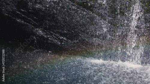 Beautiful waterfall drops splashing on water surface in slow motion calm nature background, perfect abstract video for relaxation, spa, travel, advertising and documentary projects. 120 fps video.