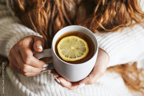 Wallpaper Mural Cup of tea with lemon. Warm drink in woman hands. Relaxing moment with hot beverage. Cozy lifestyle with sweater. Concept of autumn and winter comfort. Morning energy boost. Healthy vitamin drink. Torontodigital.ca