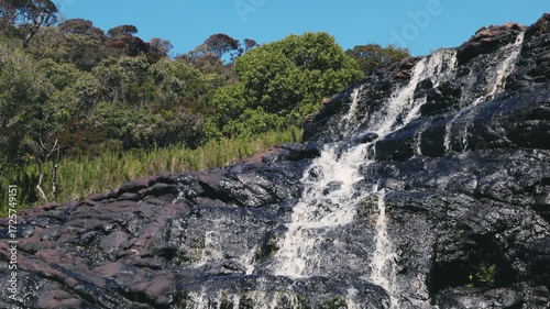 Beautiful waterfall streams flowing down the cliff in slow motion against the background of calm nature, an ideal abstract video for relaxation, spa, travel, advertising projects. Video at 120 fps.