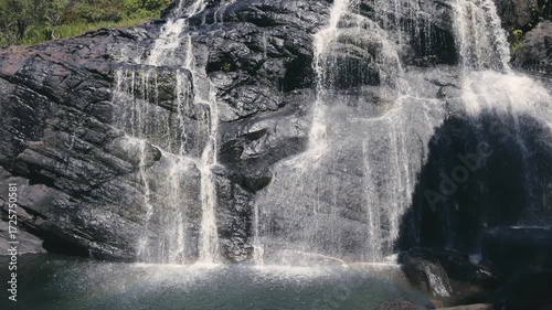 Beautiful waterfall streams flowing down the cliff in slow motion against the background of calm nature, an ideal abstract video for relaxation, spa, travel, advertising projects. Video at 120 fps.