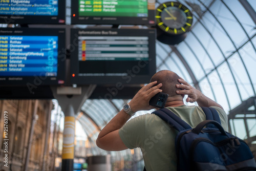 Fotografia Worried man waiting for delayed airplane or train at station during travel