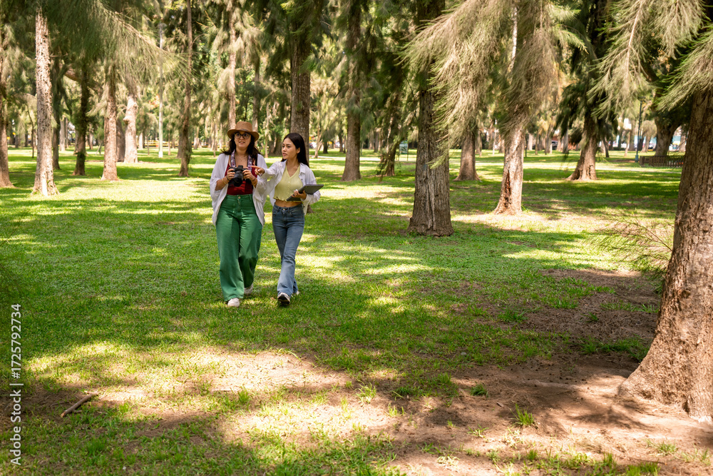 Fototapeta premium Two female biology students doing fieldwork in a forest