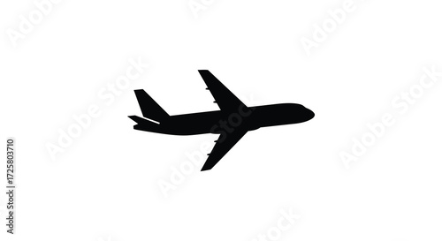 A black airplane flying against a white background striking silhouette