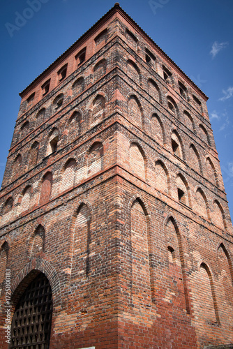 A tall brick building with arched windows and a large archway
