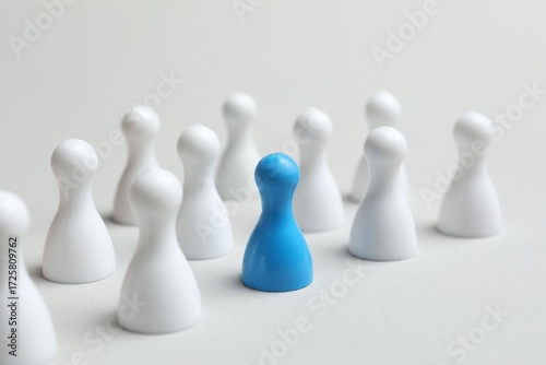 Foto Color pawn among white ones on the table