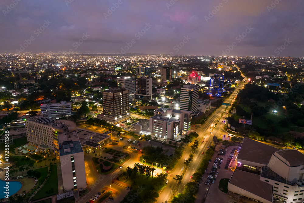 Fototapeta premium Accra, Ghana at night, aerial view of city lights and urban landscape under a twilight sky.