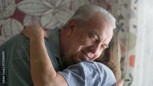 Elderly couple hugging in a room at home, close-up