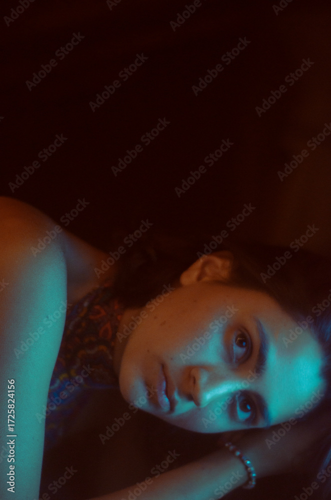 Fototapeta premium retrato oscuro de mujer con iluminacion cian y naranja